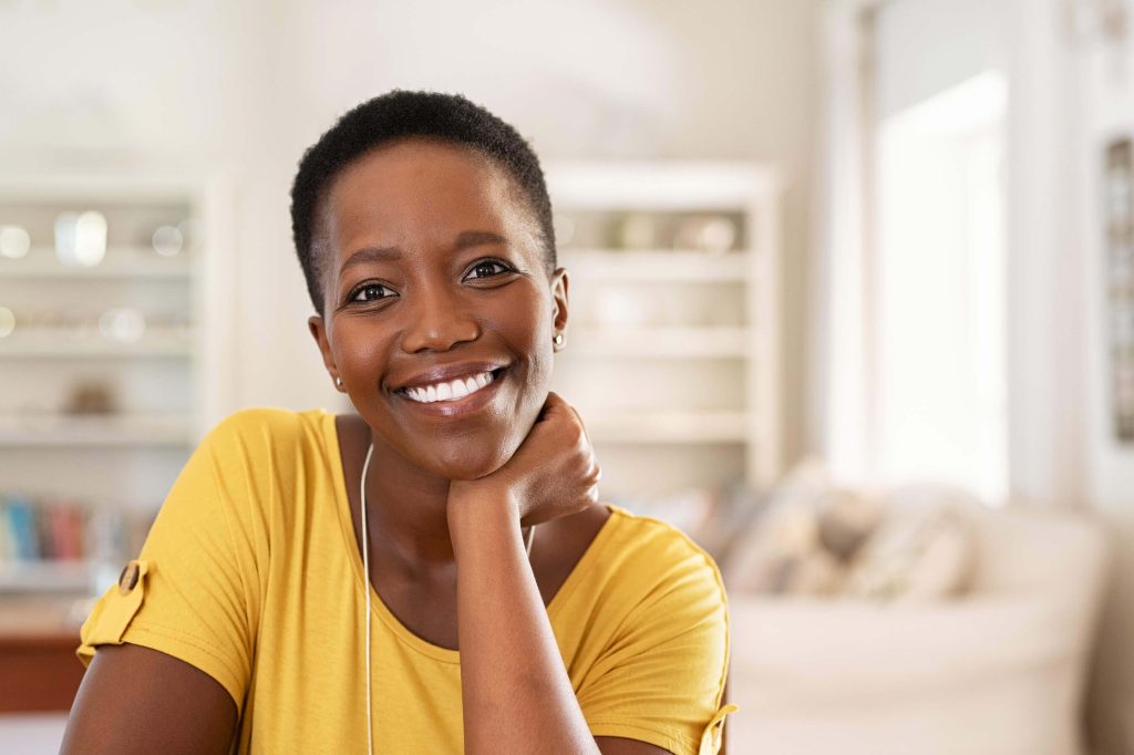 A woman smiling at home, comfortable and free of dry eye irritation