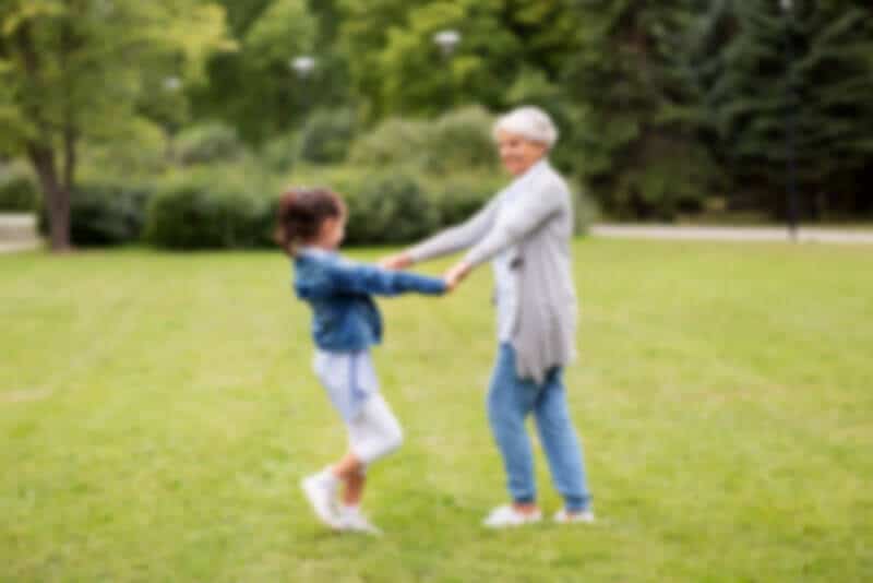 A grandmother playing with a child, seen as a hazy blur — how the world looks through a cataract