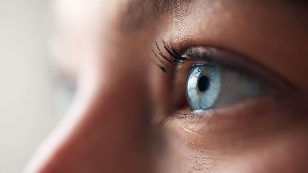 Close-up profile of an eye, showing the clear curve of the cornea over the iris
