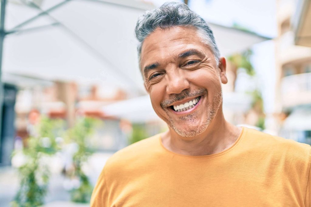 A smiling man in his fifties outdoors, managing his diabetes to protect his sight