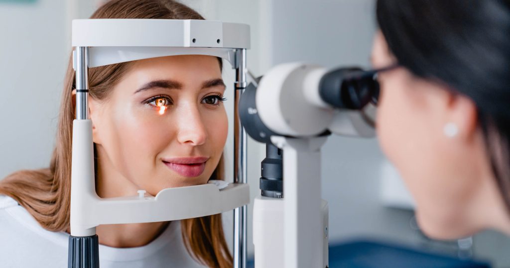 An Access Eye clinician examining the inside of a patient's eye at an imaging device